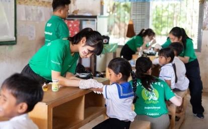 カンボジアの学校でヘルスチェックを行う高校生ボランティアたち